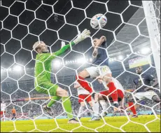  ?? The Associated Press Martin Meissner ?? France forward Kylian Mbappe (10) scores against Denmark goalkeeper Kasper Schmeichel in the 86th minute of France’s 2-1 win Saturday at Stadium 974.