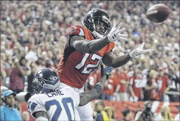  ?? CURTIS COMPTON / CCOMPTON@AJC.COM ?? The Falcons’ Mohamed Sanu catches a touchdown pass over the Seahawks’ Jeremy Lane for a 36-13 lead in the fourth quarter. It was the last of Matt Ryan’s three TD passes. He earlier led a nine-play, 99-yard TD drive that featured all passes.