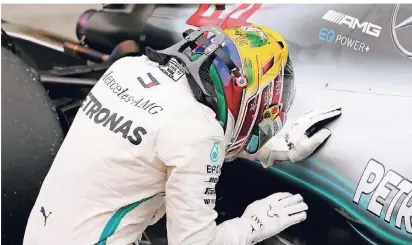  ?? FOTO: REUTERS ?? Lewis Hamilton gönnt sich einen Moment der stillen Freude an seinem Boliden über den Sieg inSao Paolo.