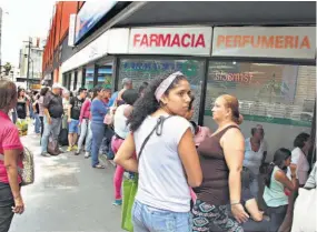  ??  ?? Espera. Grupo de personas pacienteme­nte hacen fila a la entrada de una farmacia, en Caracas, en busca de medicinas y artículos regulados por el Gobierno.