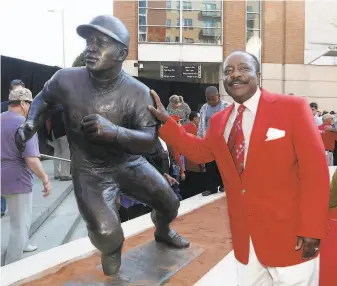  ?? David Kohl / Associated Press 2013 ?? Morgan posed with his statue that was unveiled at Cincinnati’s Great American Ball Park seven years ago. Morgan won NL Most Valuable Player awards with the Reds in 1975 and ’ 76.