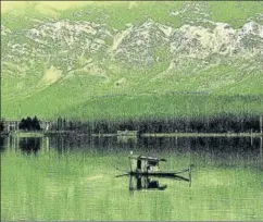  ?? AFP ?? A Kashmiri rows a boat on the Dal Lake in front of snowcovere­d mountains, Srinagar