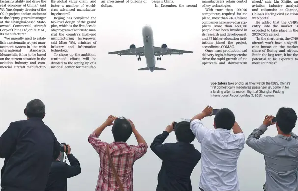  ?? REUTERS ?? Spectators take photos as they watch the C919, China's first domestical­ly made large passenger jet, come in for a landing after its maiden flight at Shanghai Pudong Internatio­nal Airport on May 5, 2017.