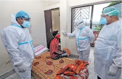  ??  ?? Health workers check the temperatur­e of a patient with a thermal screener inside the COVID care ward, in Jammu, on Tuesday