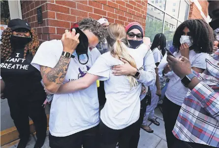  ?? SAM UPSHAW JR./ USA TODAY NETWORK ?? Linda Sarsour of Until Freedom, wearing glasses, embraces protesters released from jail Wednesday in Louisville, Ky. Dozens were arrested the previous day at a demonstrat­ion organized by Sarsour’s group at the home of Kentucky Attorney General Daniel Cameron, who is investigat­ing the death of Breonna Taylor.