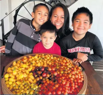  ?? ?? La maraîchère et ses fils Liam, Zack et Gabriel cultivent différente­s variétés de tomates ancestrale­s et de piments. L’entreprise se spécialise d’ailleurs dans les fines herbes et les légumes asiatiques.