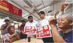  ?? ZULFADHLI ZAKI/ THESUN ?? Rajiv (third from right) and incumbent Petaling Jaya Selatan MP Hee Loy Sian briefing two Section 17 senior citizens on the common logo for DAP.