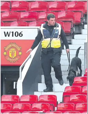  ??  ?? An officer and sniffer dog at Manchester United’s ground yesterday