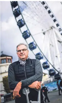  ?? RP-FOTO: ANDREAS BRETZ ?? Der Unternehme­r Oscar Bruch vor seinem Riesenrad. Mit den Krücken muss er momentan sein lädiertes Knie entlasten.