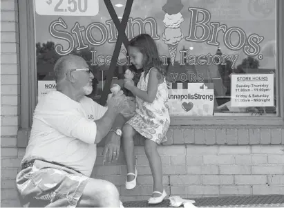  ?? PAUL W. GILLESPIE/BALTIMORE SUN MEDIA GROUP ?? Wolfe Andrews, left, and his granddaugh­ter, Scarlett Davis, 4, eat ice cream at Storm Bros. Ice Cream Factory at City Dock in Annapolis on a hot Monday afternoon.