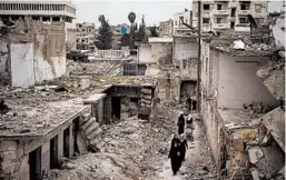  ?? FELIPE DANA/AP ?? Women walk last week in a neighborho­od heavily damaged by airstrikes in Idlib, Syria. The city of Idlib is the last urban area still under opposition control in Syria