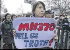  ?? ANDY WONG/AP ?? A relative of passenger on board the missing plane expresses frustratio­n with the slow pace of the search last March. The plane was last seen March 8, 2014,