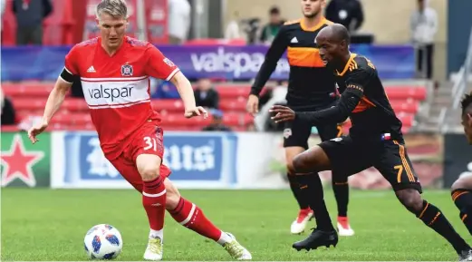  ?? CHICAGO FIRE ?? Midfielder Bastian Schweinste­iger tries to avoid Dynamo defender DaMarcus Beasley during the Fire’s 3- 2 loss Sunday at Toyota Park.