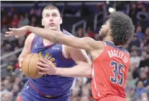  ?? PHOTO BY PATRICK SMITH/AFP ?? ONE ON ONE
Nikola Jokic (left) of the Denver Nuggets dribbles in front of Marvin Bagley of the Washington Wizards during the first half at Capital One Arena on Sunday, Jan. 21, 2024, in Washington, D.C..