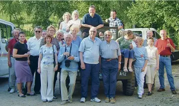  ??  ?? Below: A British guest of the Le Bouchers, Mike Gould, snapped this photo after the Leboucher fête on June 7, 2004. André is standing directly to the left of the woman in the green top perched upon the tailgate of the pickup truck. Larry’s face can be seen 5th in line from the left in the second row, squeezed between two ladies.