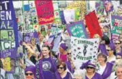  ?? REUTERS ?? Women, wearing the suffragett­e colours of green, white and violet hold banners celebratin­g the 100th anniversar­y of British women securing the right to vote.