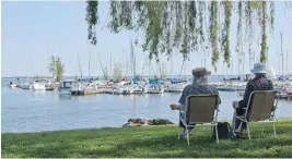  ?? PHOTO COURTESY OF THE CITY OF POINTE-CLAIRE ?? Relaxing in the shade of a willow tree near Lac St-Louis, a couple of Pointe Claire residents take in a view of the city’s marina.