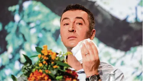  ?? Foto: Kay Nietfeld, dpa ?? Im heißen Licht der Scheinwerf­er: Parteichef Cem Özdemir fühlt sich offensicht­lich unwohl auf dem Podest. Eigentlich wollten die Grünen in Berlin das ganz große Rad drehen – doch es wurde alles zwei Nummern kleiner.