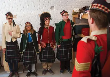  ??  ?? Clockwise from opposite: Interprete­rs show the students how to raise a flag at the Halifax Citadel; standing at attention in 78th Highlander­s uniforms; a lesson in shinglemak­ing at Port Royal; a Mi’kmaq drumming circle near the settlement. previous...