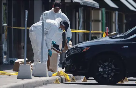 ?? COLE BURSTON THE CANADIAN PRESS ?? Police forensic officers work around the scene where an improvised explosive device ripped through a Mississaug­a restaurant on Thursday night.