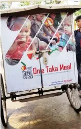  ??  ?? Volunteers distribute ‘one taka meal’ boxes to children in Dhaka’s Mirpur district.