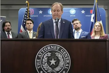  ?? ERIC GAY — THE ASSOCIATED PRESS ?? Texas state Attorney General Ken Paxton, center, flanked by his staff, makes a statement at his office in Austin, Texas, Friday, May 26, 2023. An investigat­ing committee says the Texas House of Representa­tives will vote Saturday on whether to impeach state Attorney General Ken Paxton.