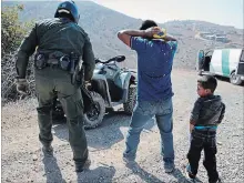  ?? JAE C. HONG THE ASSOCIATED PRESS ?? A Guatemalan father and son who crossed the U.S.-Mexico border illegally are apprehende­d by a U.S. Border Patrol agent in San Diego.