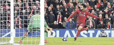  ??  ?? Liverpool’s Mohamed Salah (right) scores his side’s winning goal in the Champions League Group C match against Napoli at Anfield stadium in Liverpool, England, yesterday.