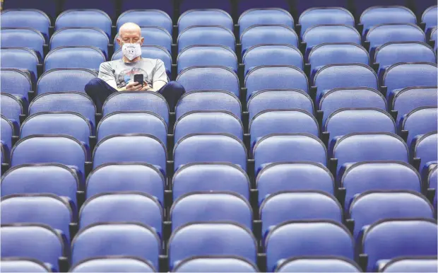  ?? Ben Mckeown / The Associated Pres Files ?? Mike Lemcke, from Richmond, Va., sits in an empty Greensboro Coliseum after NCAA college basketball games were cancelled back in March.