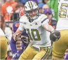  ?? KEN RUINARD/USA TODAY SPORTS ?? Georgia Tech quarterbac­k Haynes King hands off the ball playing Clemson during the fourth quarter Nov. 11 at Memorial Stadium in South Carolina.