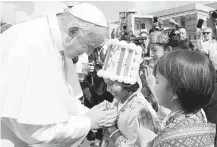  ?? Andrew Medichini / Associated Press ?? Pope Francis is greeted by children in traditiona­l clothes upon his arrival at the Yangon, Myanmar, airport Monday. The pontiff is in Myanmar for the first stage of a weeklong visit.