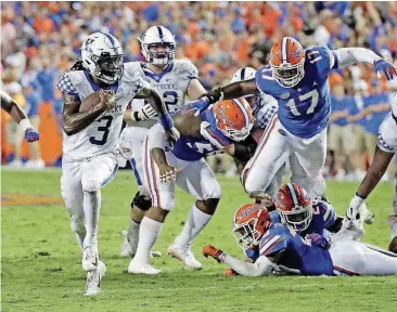  ?? [AP PHOTO] ?? Kentucky quarterbac­k Terry Wilson (3) runs past the Florida defense for a 24-yard touchdown during the Wildcats’ 27-16 win — their first over the Gators since 1986 — on Saturday.