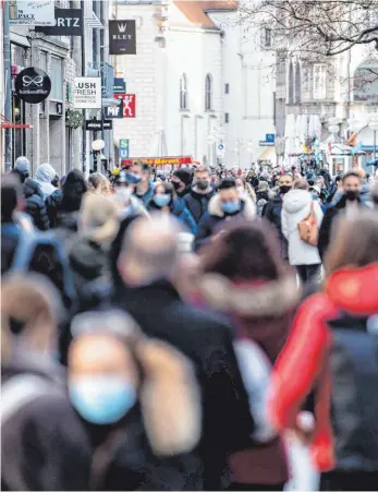  ?? FOTO: MATTHIAS BALK/DPA ?? Zahlreiche Passanten mit Masken drängen sich durch eine Einkaufsst­raße in der Münchener Innenstadt. Ab Mittwoch tritt der harte Lockdown in Kraft, mit dem auch der Einzelhand­el in der Innenstadt schließen muss.