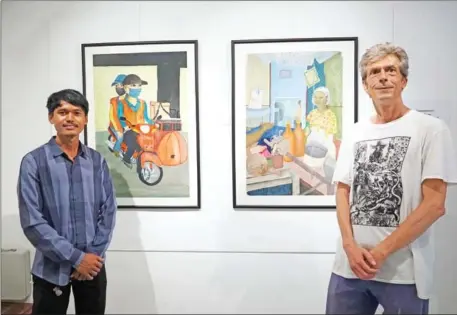  ?? HONG RAKSMEY ?? Ernst Altmann (right) and Cambodian artist Say Chearun display their paintings at Meta House on April 23.