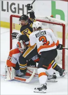 ?? GENE J. PUSKAR — THE ASSOCIATED PRESS ?? Pittsburgh Penguins’ Sidney Crosby (87) is shoved into Philadelph­ia Flyers goaltender Brian Elliott (37) by Radko Gudas (3) during the first period in Game 1 of an NHL first-round hockey playoff series in Pittsburgh, Wednesday. The Penguins won 7-0.