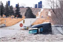  ?? RYAN SODERLIN/OMAHA WORLD-HERALD ?? A tractor-trailer was swept off the road by floodwater­s Thursday in Arlington, Neb. Evacuation­s forced by flooding have occurred in several eastern Nebraska communitie­s