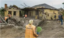  ?? DAVID GOLDMAN/AP ?? An person armed with a broom arrives to help with cleanup Friday at a house damaged by an airstrike in Kramatorsk, Ukraine. Eleven rockets hit the town overnight.