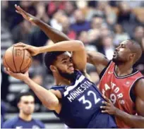  ?? AP ?? Serge Ibaka, de Toronto Raptors, defiende al centro de Minnesota Timberwolv­es, Karl-Anthony Towns durante el partido entre ambos conjuntos anoche en Toronto.