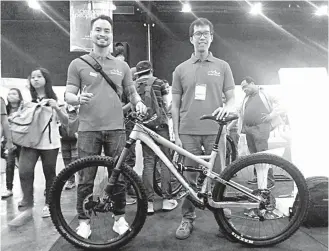  ??  ?? ‘TEAM RUROK AND THEIR INNOVATIVE BIKE — PJ Tolentino (left), head of Rurok Industries, along with one of his associates, Chino Mendoza, proudly presents the Rurok Cordillera bike prototype during the Department of Science and Technology­National Science...