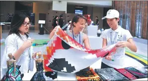  ?? ZHANG QINGQING / FOR CHINA DAILY ?? A participan­t in the 22nd UNWTO General Assembly shows interest in a Sichuan-made scarf.