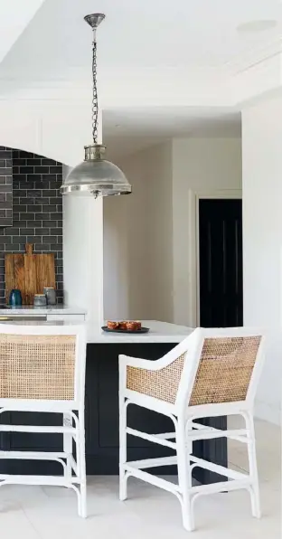  ??  ?? KITCHEN NOOK “‘Practical and beautiful’ was the mantra for the high traffic areas,” says interior designer Leanne, and this space off the kitchen, used by Gary and Scarlett (pictured below), fits the brief perfectly. Spills and marks easily wipe off the Herringbon­e outdoor fabric from Westbury Textiles that has been used on the kitchen banquette, while a glass top protects the timber table.