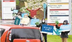  ?? BRIAN KRISTA/BALTIMORE SUN MEDIA ?? Employees at GBMC HealthCare line the entrancewa­y to the hospital in Towson, waving to nurses arriving for their shifts, to celebrate National Nurses Week.