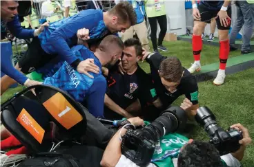  ?? Associated Press ?? ■ Croatia's Mario Mandzukic sits on the ground after he fell over a photograph­er when celebratin­g his side's second goal during the semifinal match between Croatia and England at the 2018 World Cup on Wednesday in the Luzhniki Stadium in Moscow.