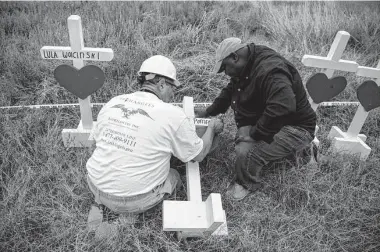  ?? Carolyn Van Houten/Washington Post ?? Greg Zanis, left, and the Rev. Van Jordan write the names of victims on crosses along the edge of a field next to Sutherland Springs First Baptist Church on Nov. 8, 2017, in Sutherland Springs.