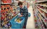  ?? ARIC CRABB — BAY AREA NEWS GROUP ?? Martinez Community Academy student Mason Richardson stocks shelves with candy at a Walgreens store on last year in Martinez.