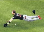  ?? MADDIE MEYER/GETTY IMAGES ?? Miami’s Cole Gillespie tries to make a diving catch, but misses the ball during Tuesday night’s game against Boston at Fenway Park.