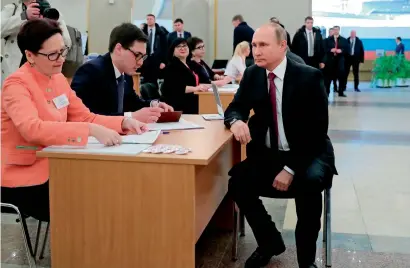  ?? AFP ?? Vladimir Putin waits to get his ballot as he arrives to vote at a polling station in Moscow sunday. —