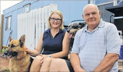  ?? MILLICENT MCKAY/JOURNAL PIONEER ?? Kathy Pendergast, left, and Donnie Arsenault, with dogs Luck and Jack, lost their home in a fire in May. Now they are now in a battle with their insurer over the value of the property.