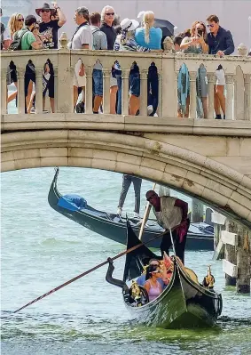  ??  ?? Il ponte della Paglia a Venezia: la città afflitta dal turismo cafone vieta di sostare sui gradini