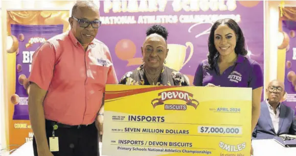  ?? ?? Devon Biscuits Brand Manager Sherene Bryan (right) hands over a symbolic cheque to George Ledgister, acting executive director of INSPORTS, while Sport Minister Olivia Grange shares in the occasion at the launch of the INSPORTS All-island Primary Schools Athletics Championsh­ips at National Indoor Sports Centre on Tuesday.